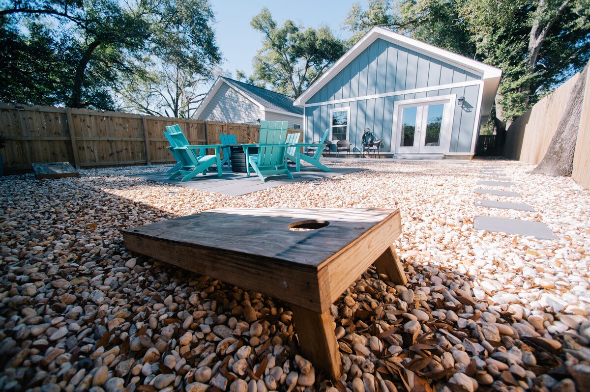 Backyard with cornhole game and outdoor seating at Auer House vacation rental
