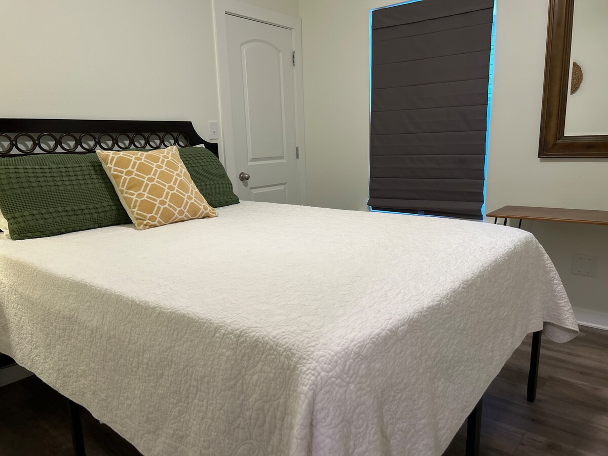 Guest bedroom one with blackout shades and Samsung Smart TV at Auer House