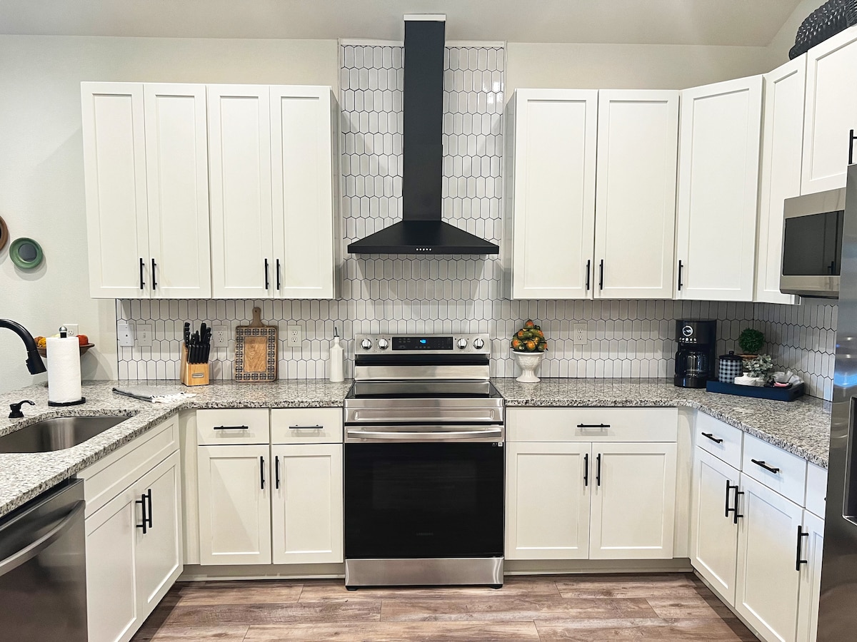 Fully equipped kitchen with granite countertops and Samsung appliances at Auer House