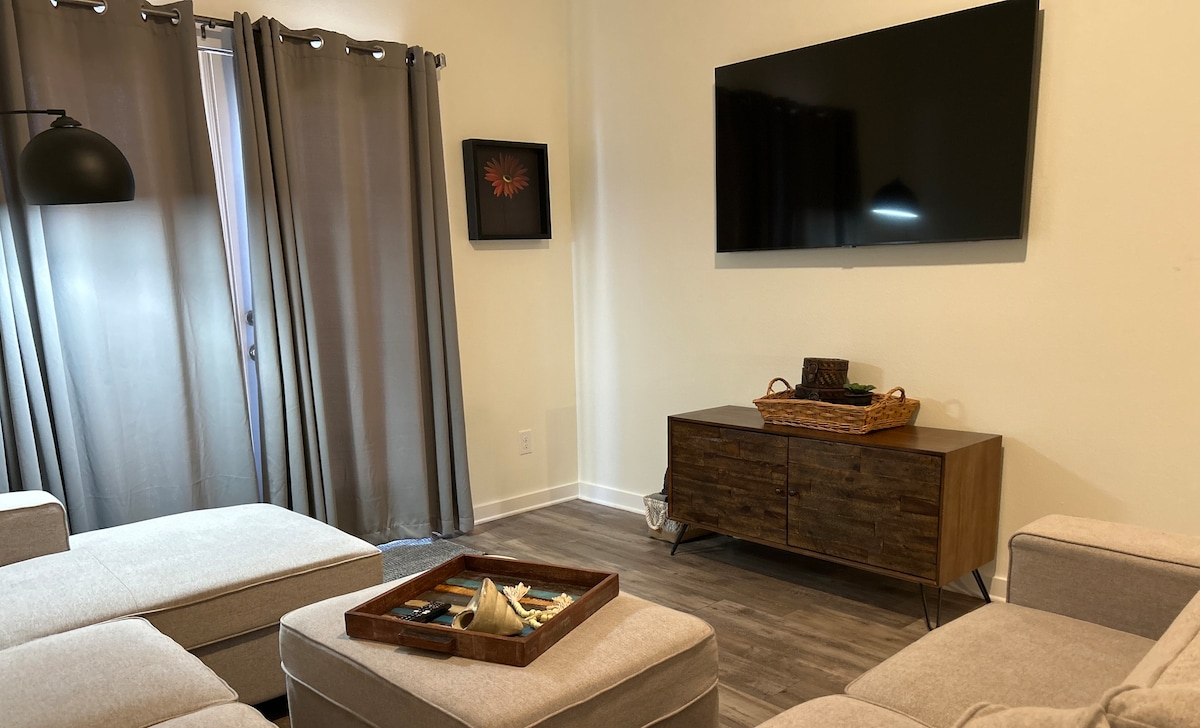 Living room with hardwired workspace setup including monitor and charging station